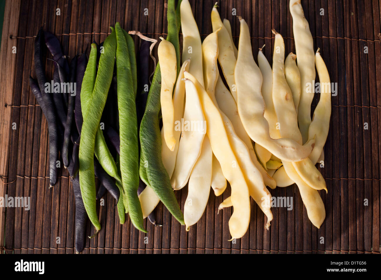 Runner and French beans on a bamboo mat.Green,black and cream varieties