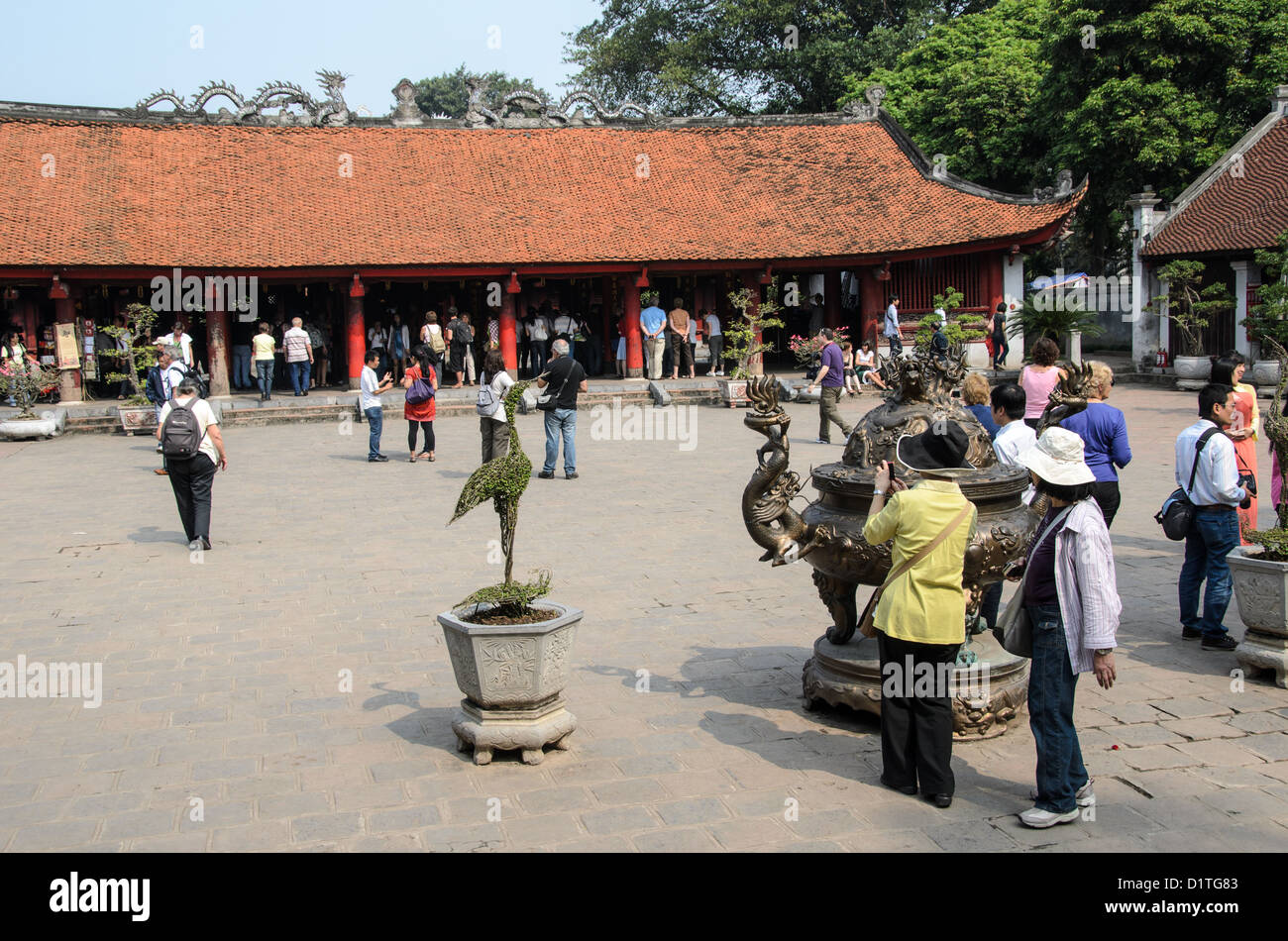 HANOI, Vietnam - Tourists in one of the courtyards of the Temple of Literature in Hanoi. The temple was built in 1070 and is one of several temples in Vietnam which are dedicated to Confucius, sages and scholars. Stock Photo