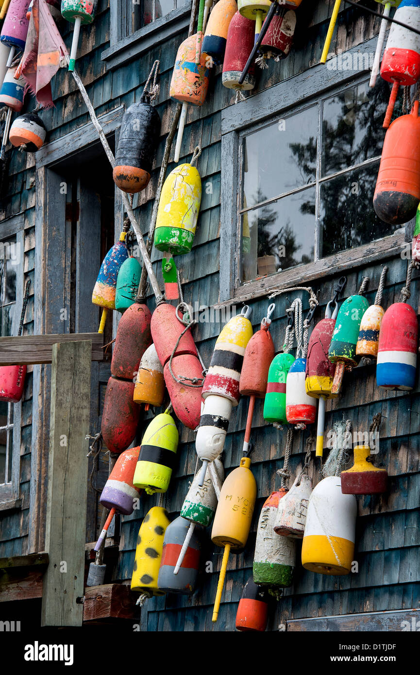 Colorful buoys adorn a rustic coastal shack, Bernard, Mt Desert Island, Maine, USA Stock Photo