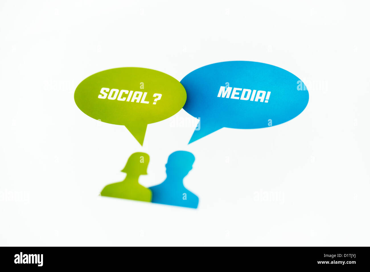 Two figures with speech bubbles and words "Social" and "Media" printed on paper. Isolated on white. Stock Photo