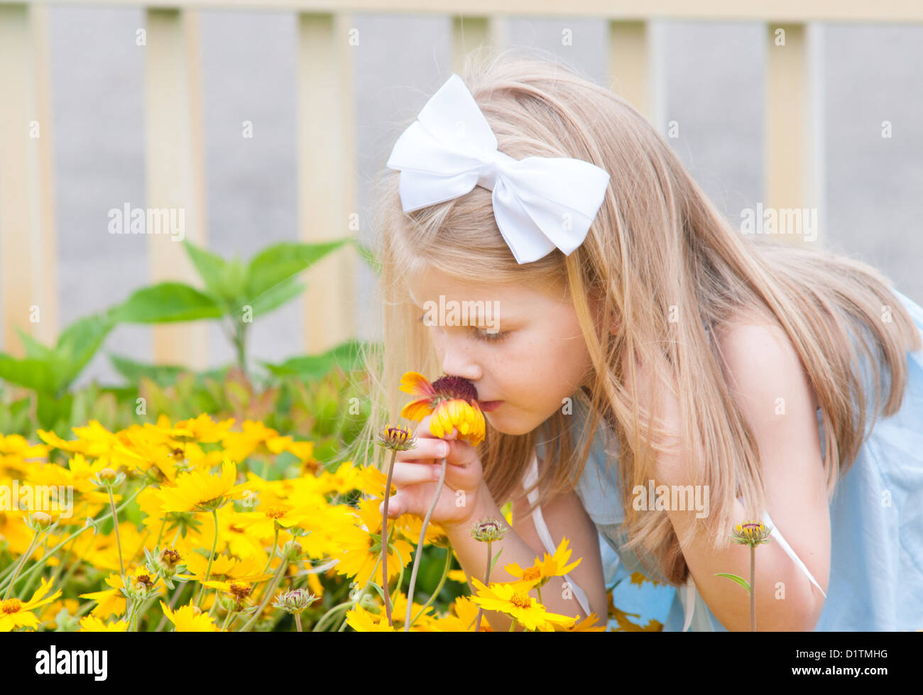 Young girl smelling a flower Stock Photo - Alamy