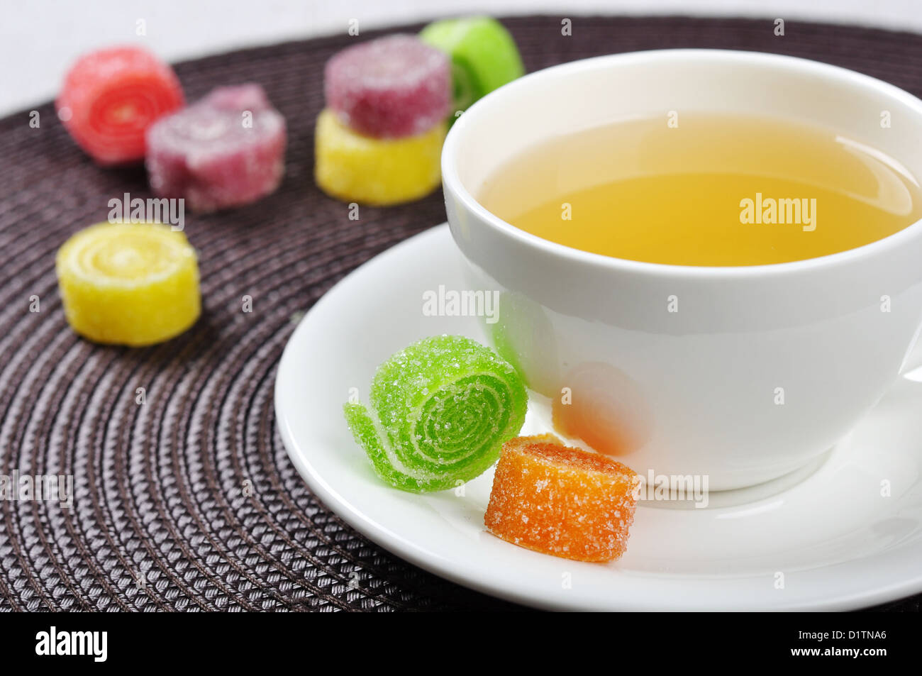 Tea in cup and sweet jelly candies on table Stock Photo