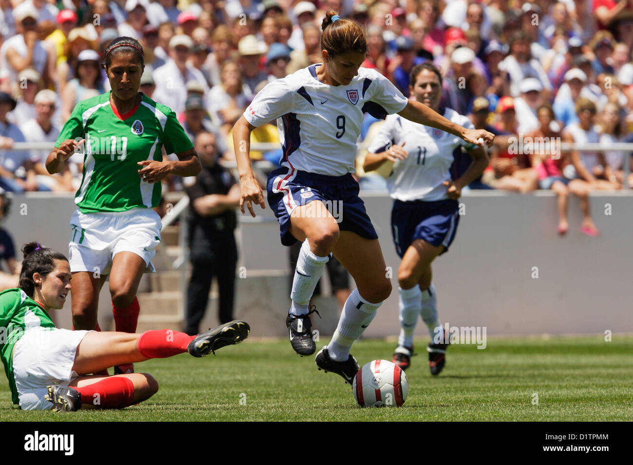 Mia Hamm of the United States avoids a tackle during a friendly soccer match against Mexico at University Stadium on May 9, 2004 Stock Photo