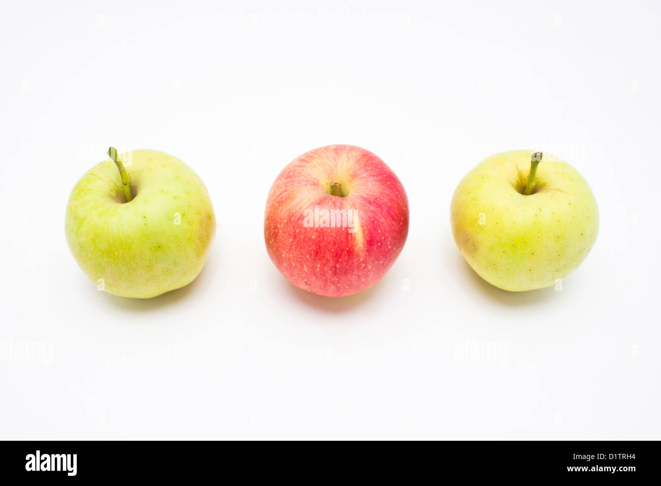 Red apple among green apples isolated on white background. Stock Photo