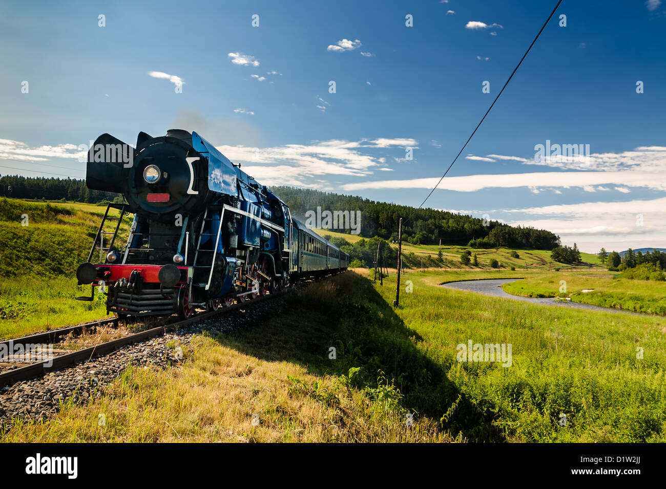 Steam engine locomotive train moving next to the river Stock Photo