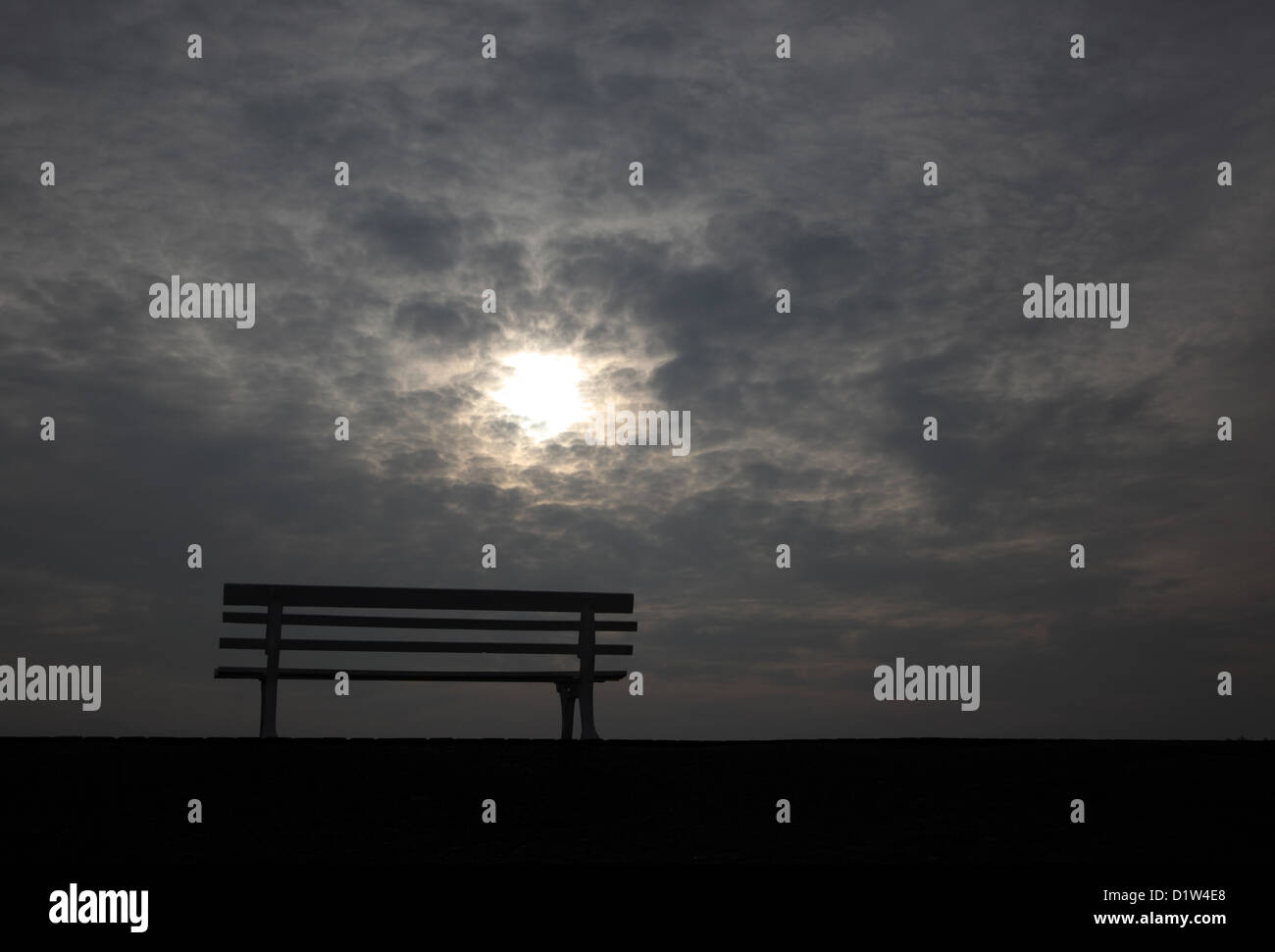 Hanover, silhouette, empty park bench in front of cloudy sky Stock Photo