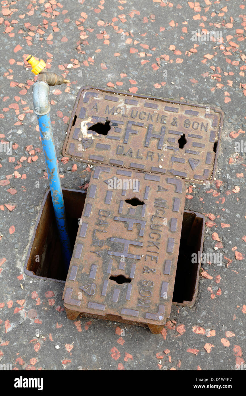 Temporary water supply standpipe installed on a pavement in a cast iron Fire Hydrant Surface Box manufactured by A McLuckie, Glasgow, Scotland, UK Stock Photo