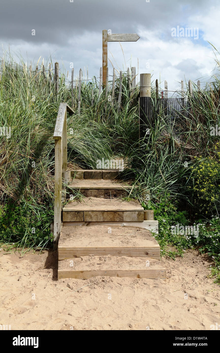 A set of wooden steps leading to Troon Beach with a direction sign, Ayrshire, Scotland, UK Stock Photo