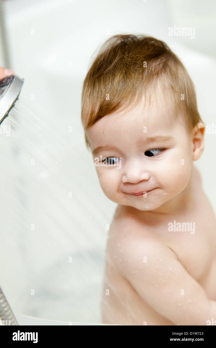 Nine months baby girl startled by water at her back in the bathroom