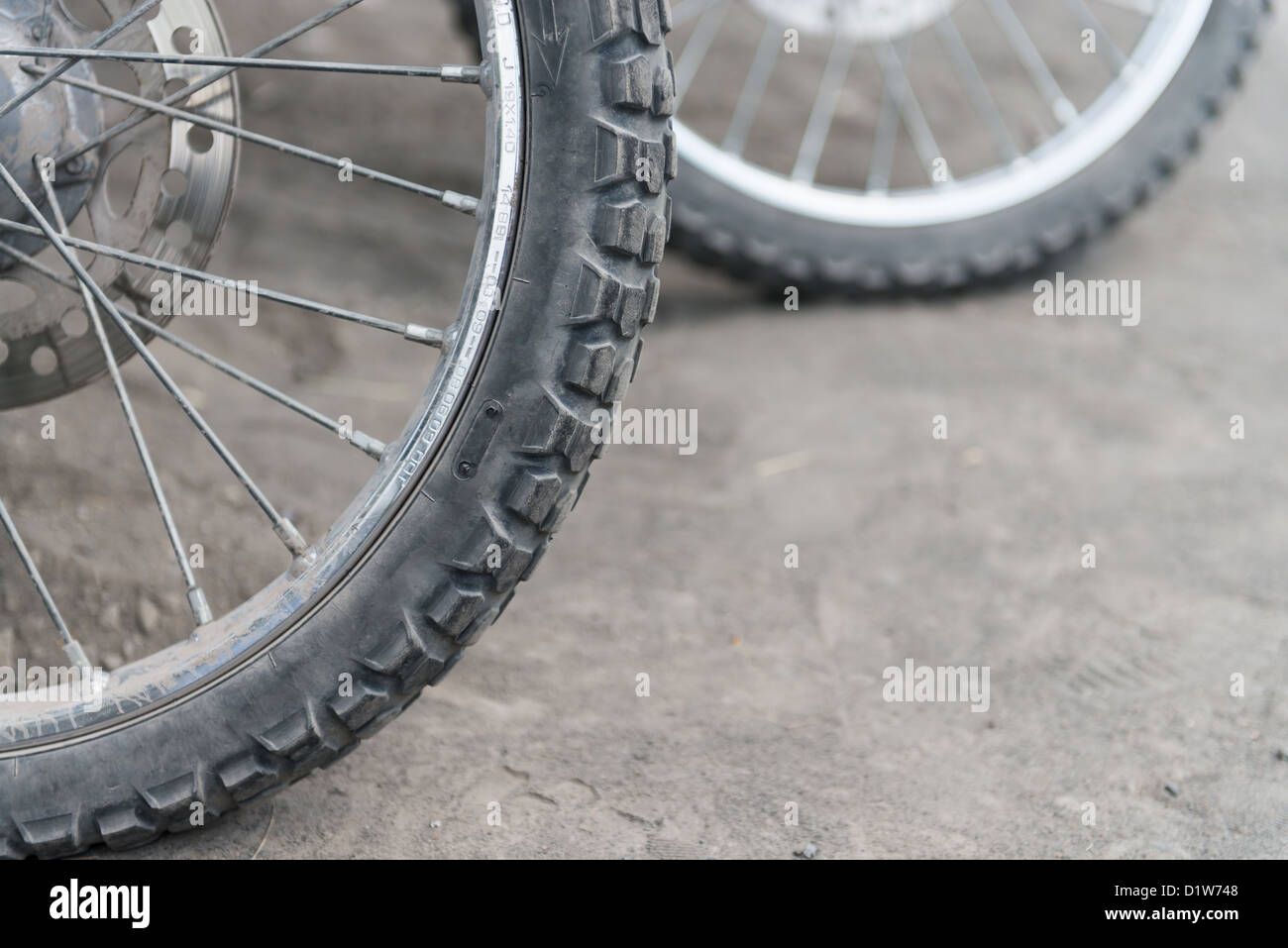 Offroad motorcycle tires on dusty ground. Selective focus on the front