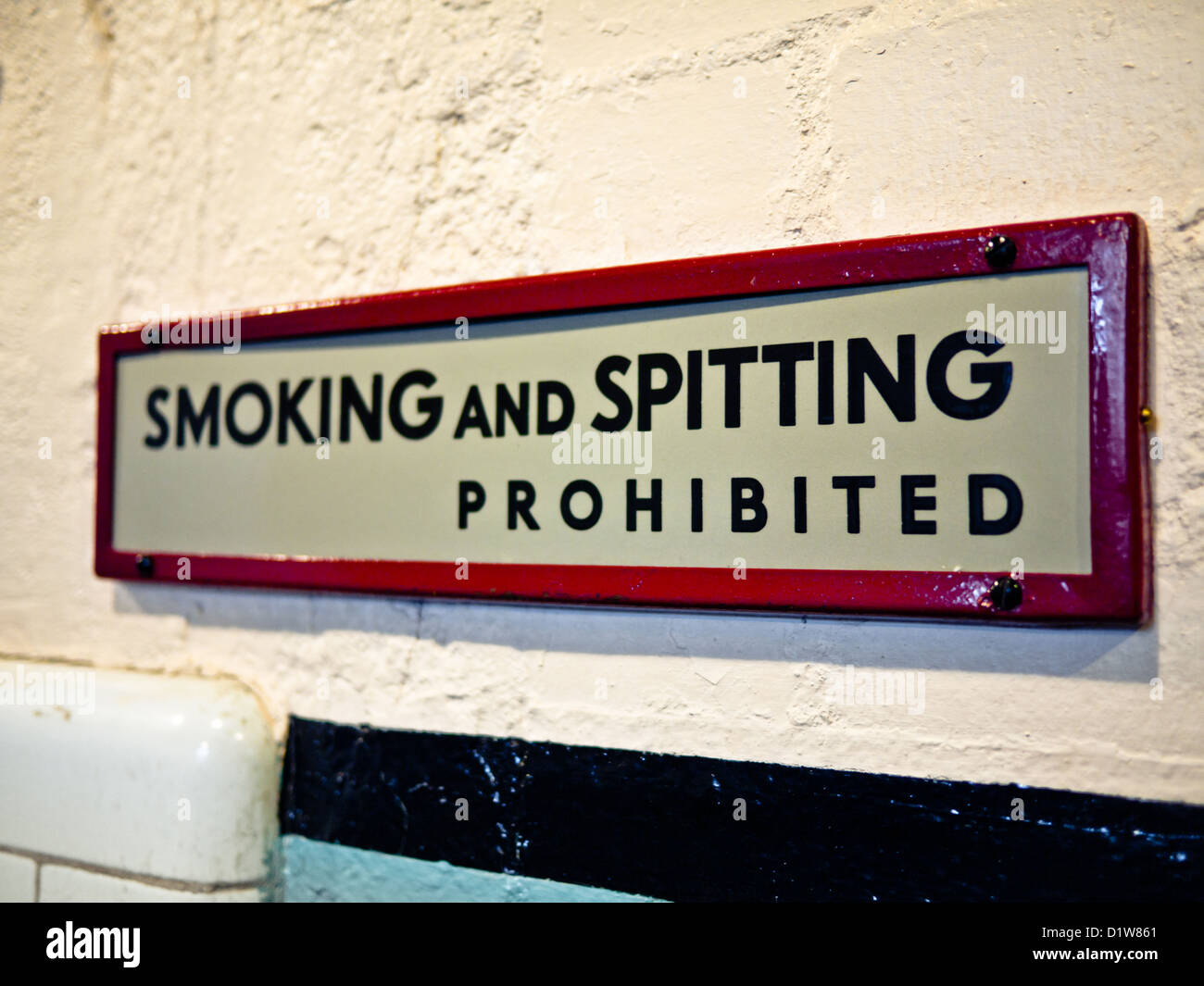 White sign with black writing reading "Smoking and Spitting prohibited