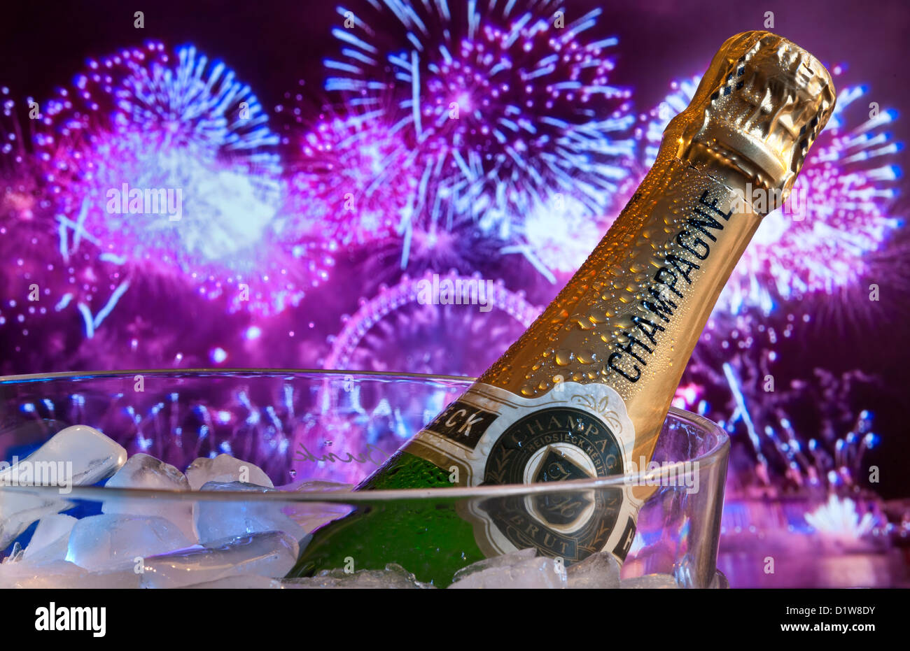 Champagne & Fireworks wine cooler ice cubes London Eye Wheel  behind at night with big celebration party fireworks & laser lights SouthBank London UK Stock Photo