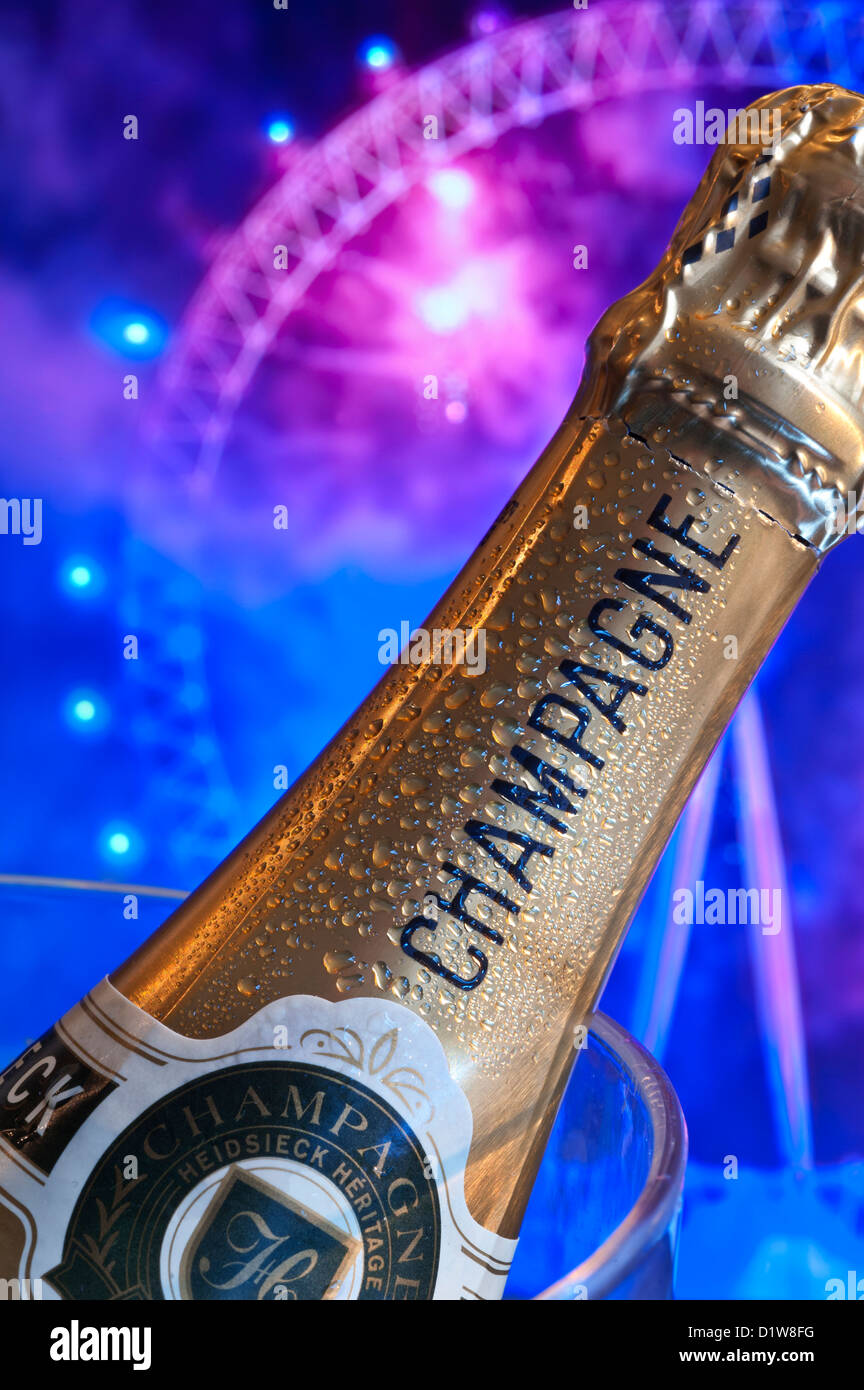 Bottle of champagne on ice in wine cooler with London Eye behind at night with big celebration party fireworks Stock Photo