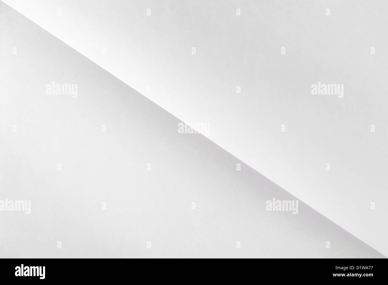 white sheet of paper folded in two diagonally with texture Stock Photo