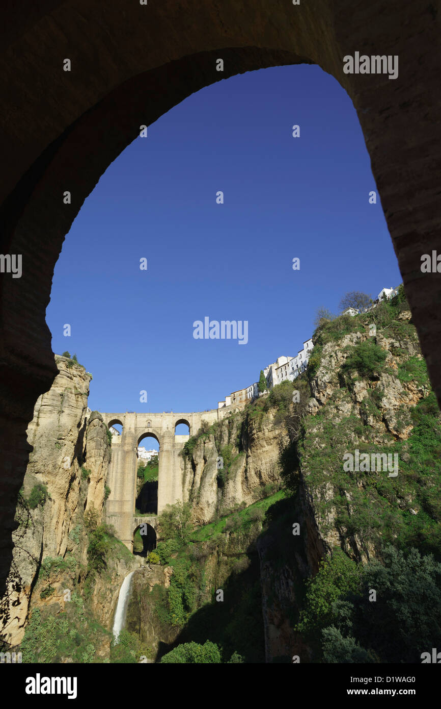 Ronda. The bridge and Tajo gorge seen from inside the old Moorish gateway of the Puerta de los Molinos Stock Photo