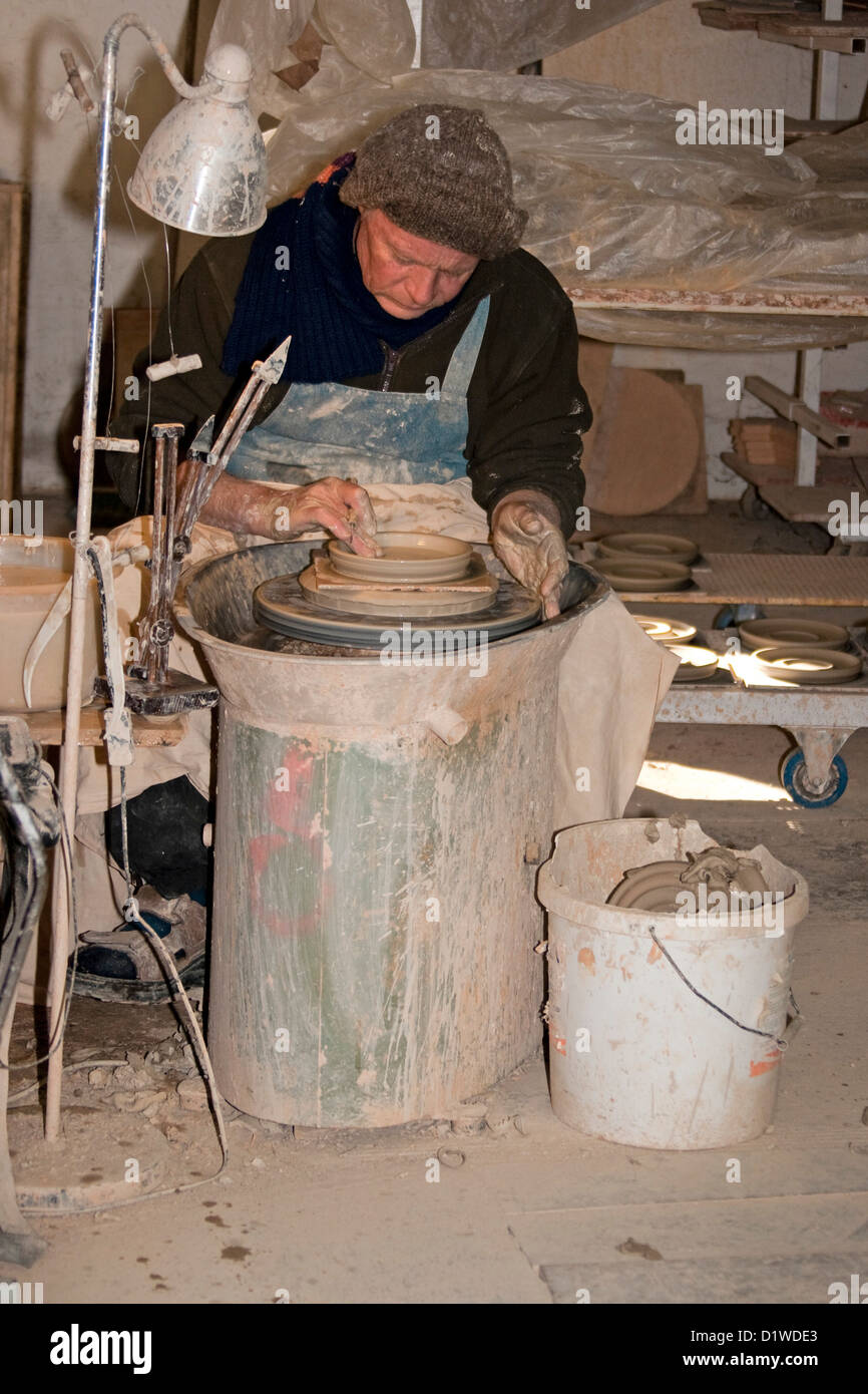 Man working with clay and potter's wheel at commercial pottery Stock ...