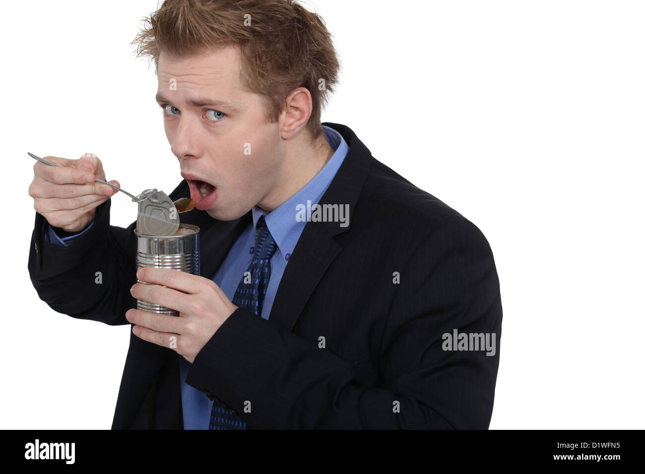 Man eating dog food in a tin can Stock Photo