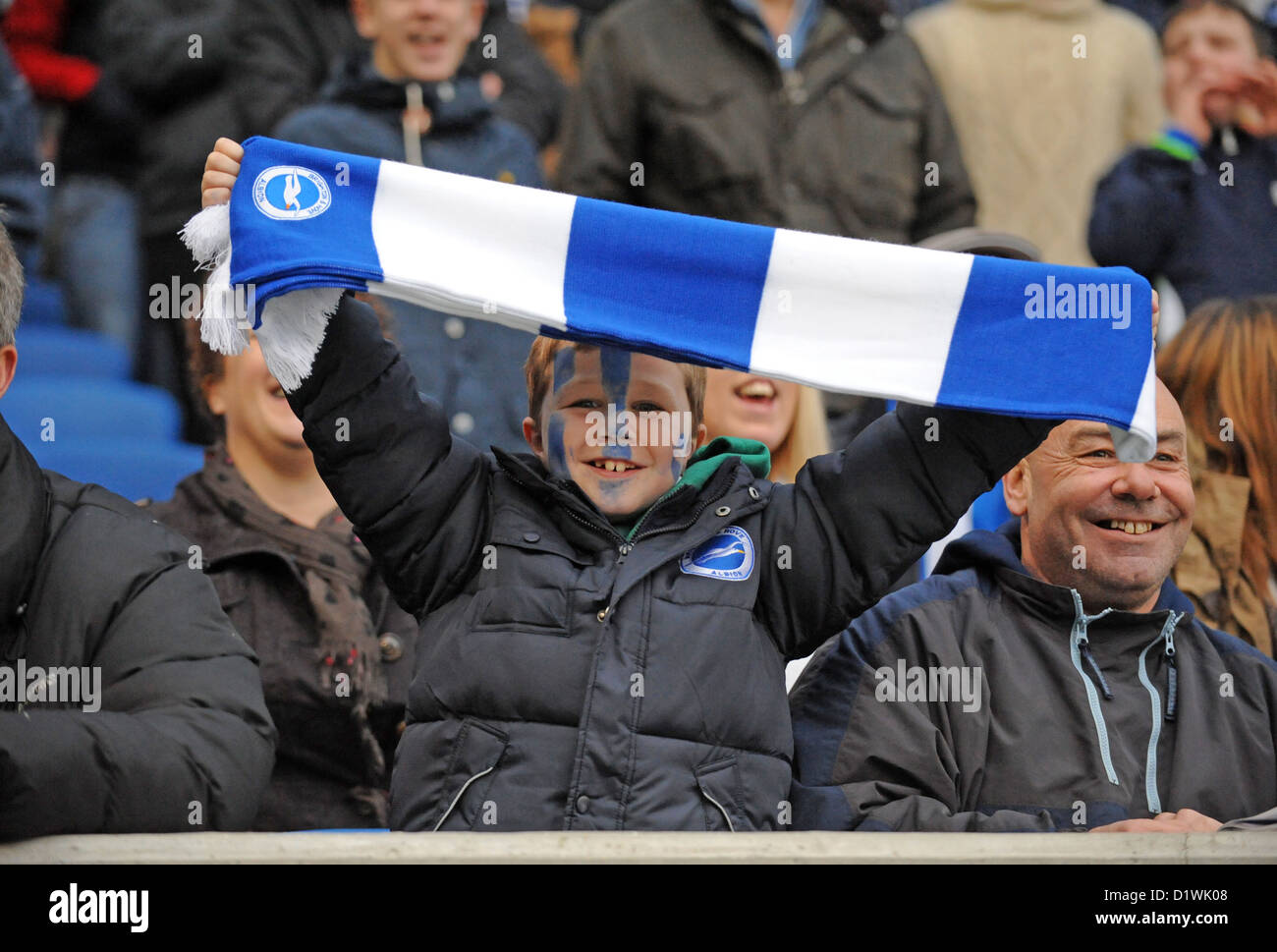 Young Brighton and Hove Albion football fan with a blue and white scarf cheering on his team Stock Photo