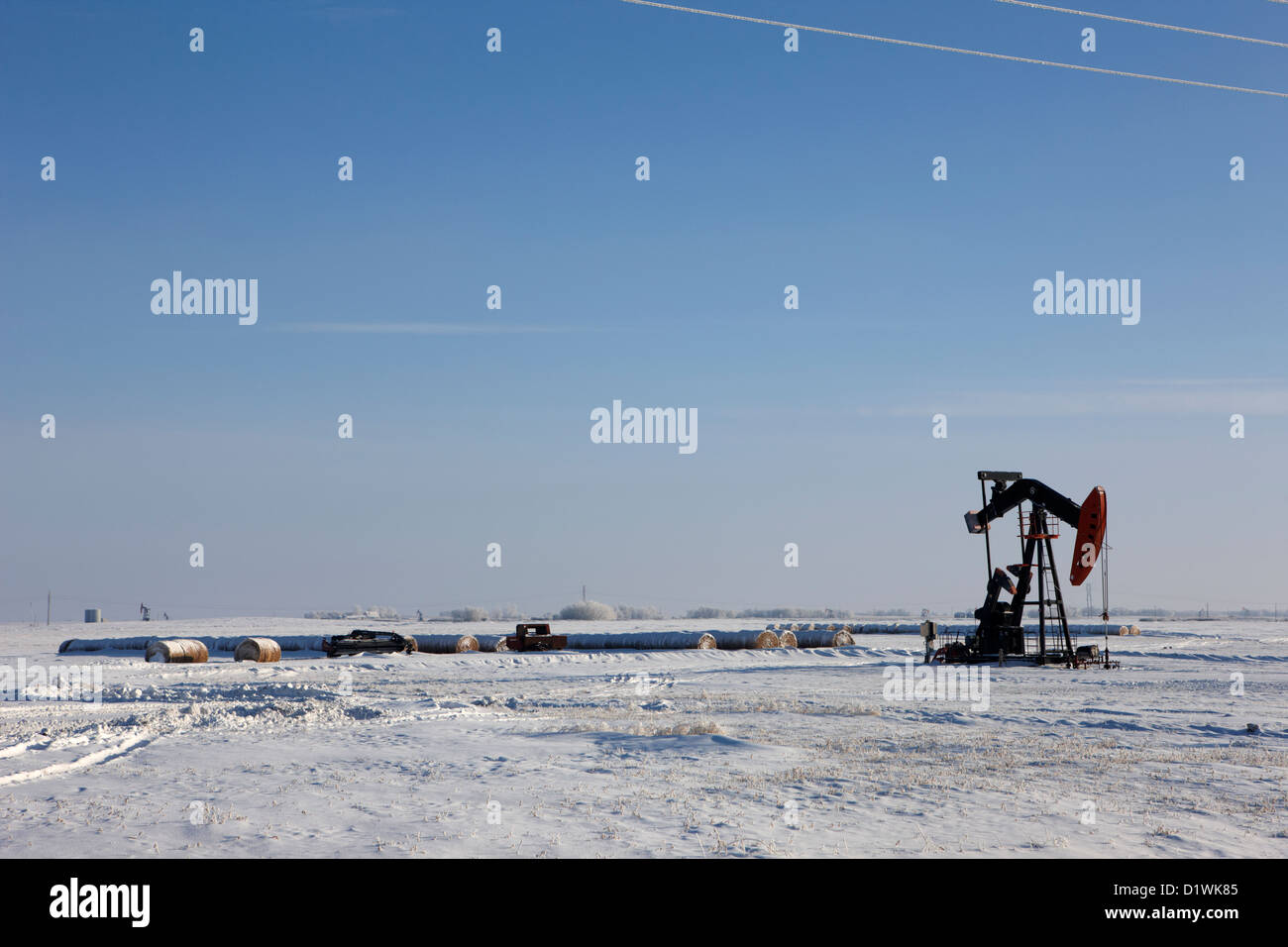 snow covered prairie agricultural farming land with pumpjacks oilfield winter Forget Saskatchewan Canada Stock Photo