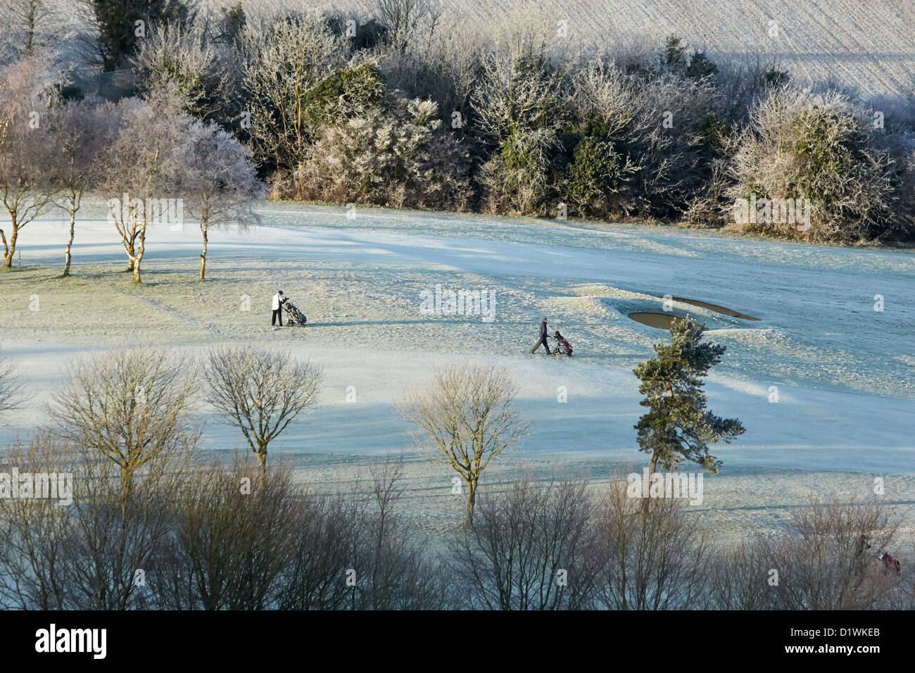 Golfers play on a hoarfrost covered golf course in the Chilterns near Golfers play on a hoarfrost covered golf course in the Chilterns near