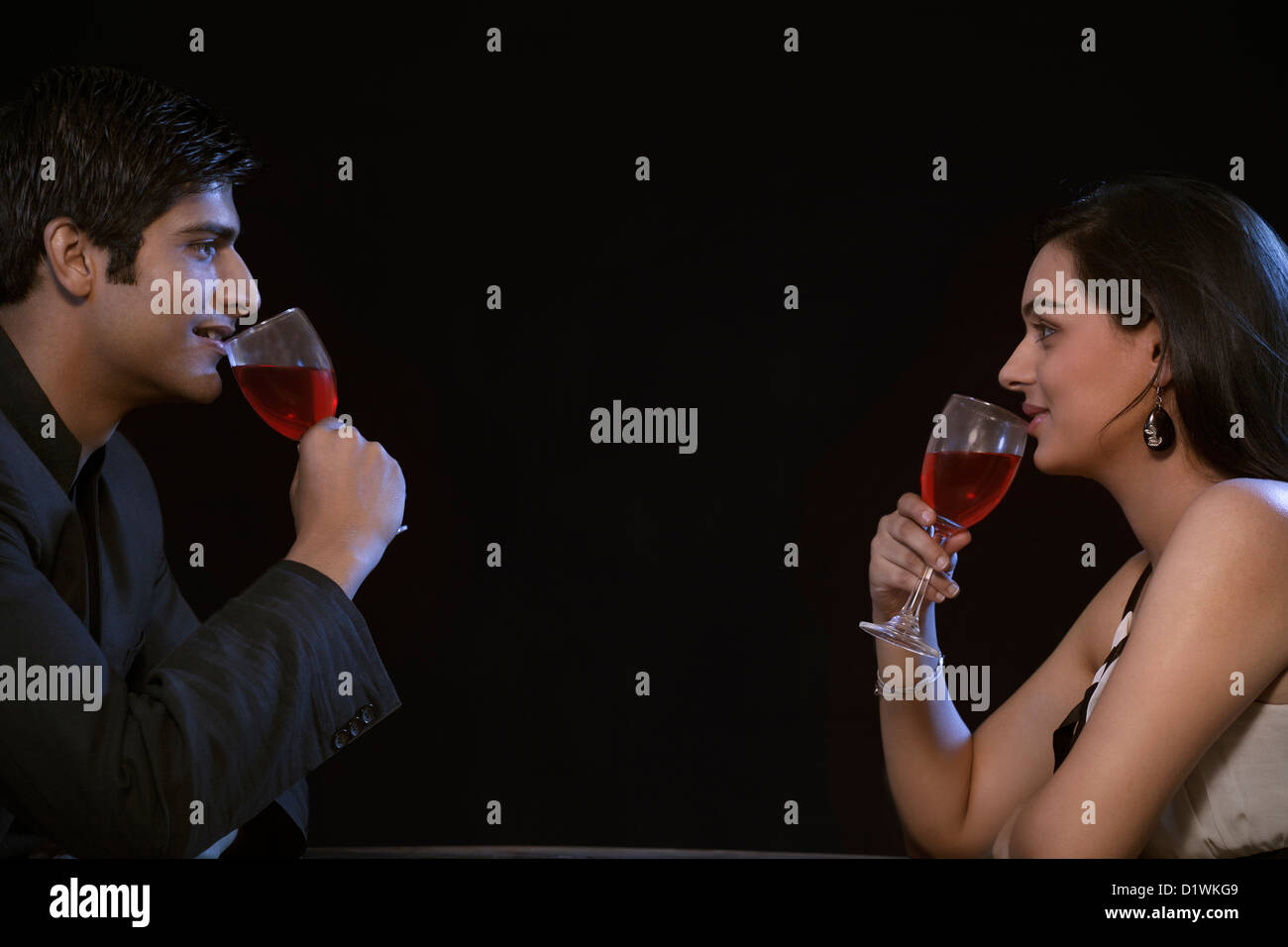 Young couple enjoying red wine on romantic date Stock Photo - Alamy