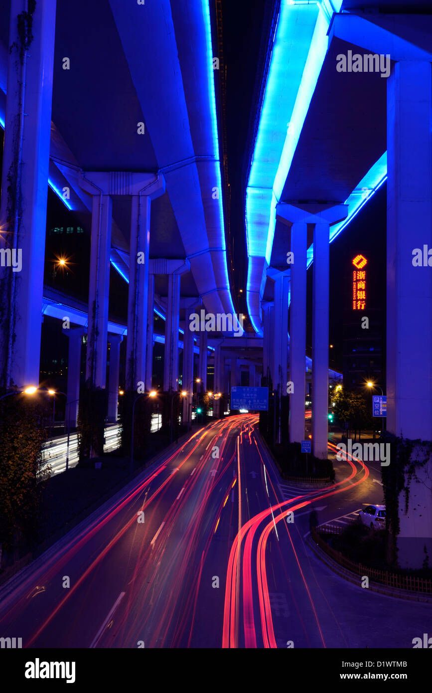 Street photography at night of Shanghai city with car trail effect below the elevated road. Stock Photo