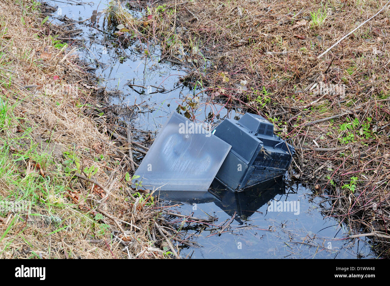 Old television dumped in drainage ditch Stock Photo Alamy