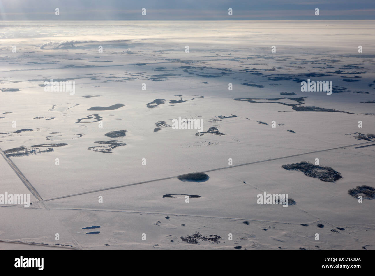aerial view of snow covered prairies and remote isolated farmland in Saskatchewan Canada Stock Photo
