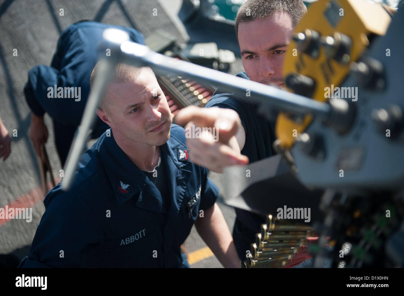 Fire Controlman 2nd Class demonstrates the procedure for loading rounds ...