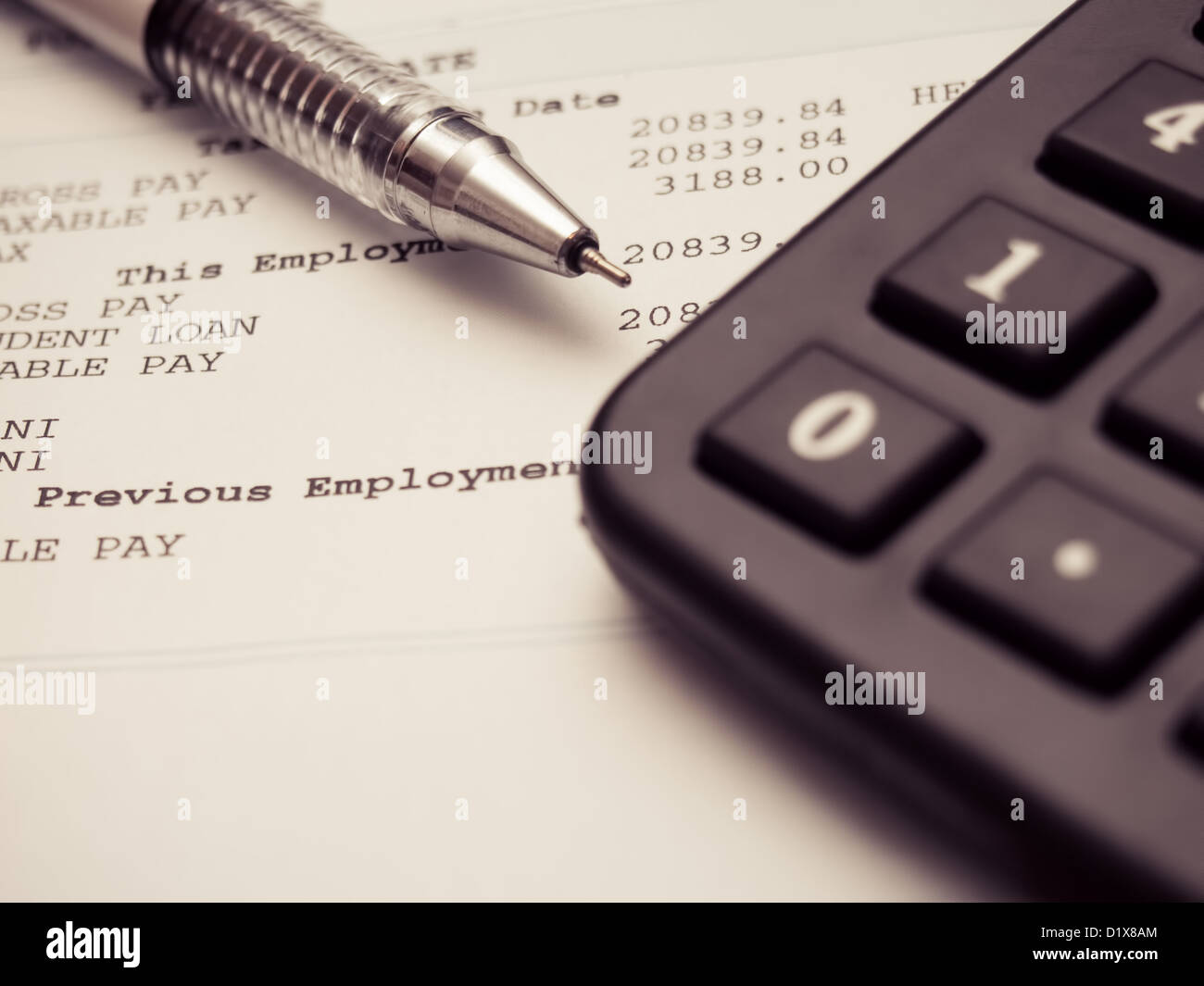 A payslip with a pen and calculator to assist in working out personal finances Stock Photo