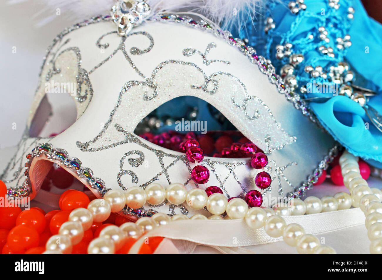 A white and glittery masquerade ball mask with party beads and pearls Stock Photo