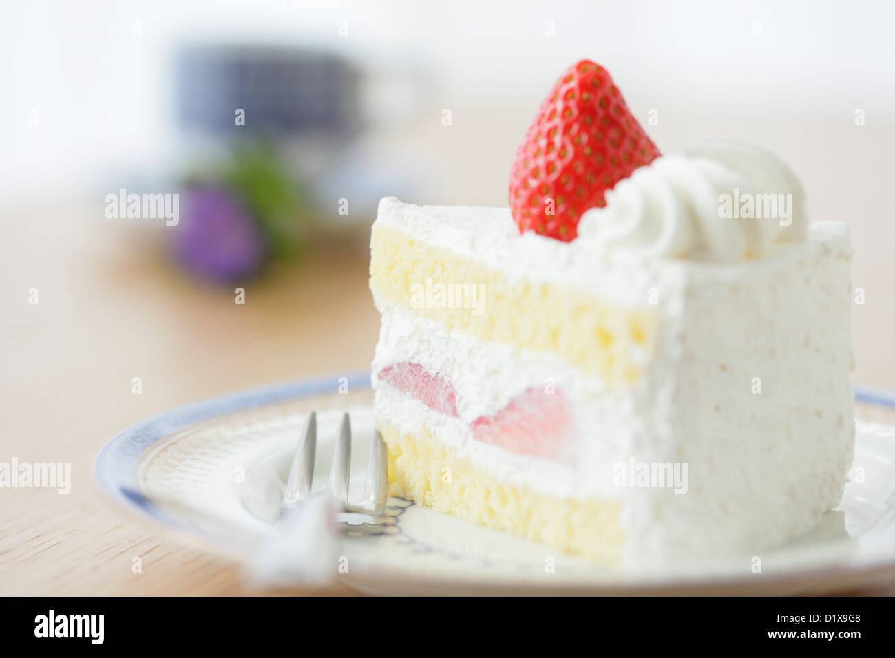 Slice of strawberry shortcake on a wooden table Stock Photo
