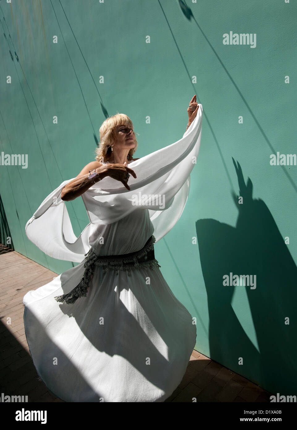 Woman in whitle dancing in the strong sun. Stock Photo