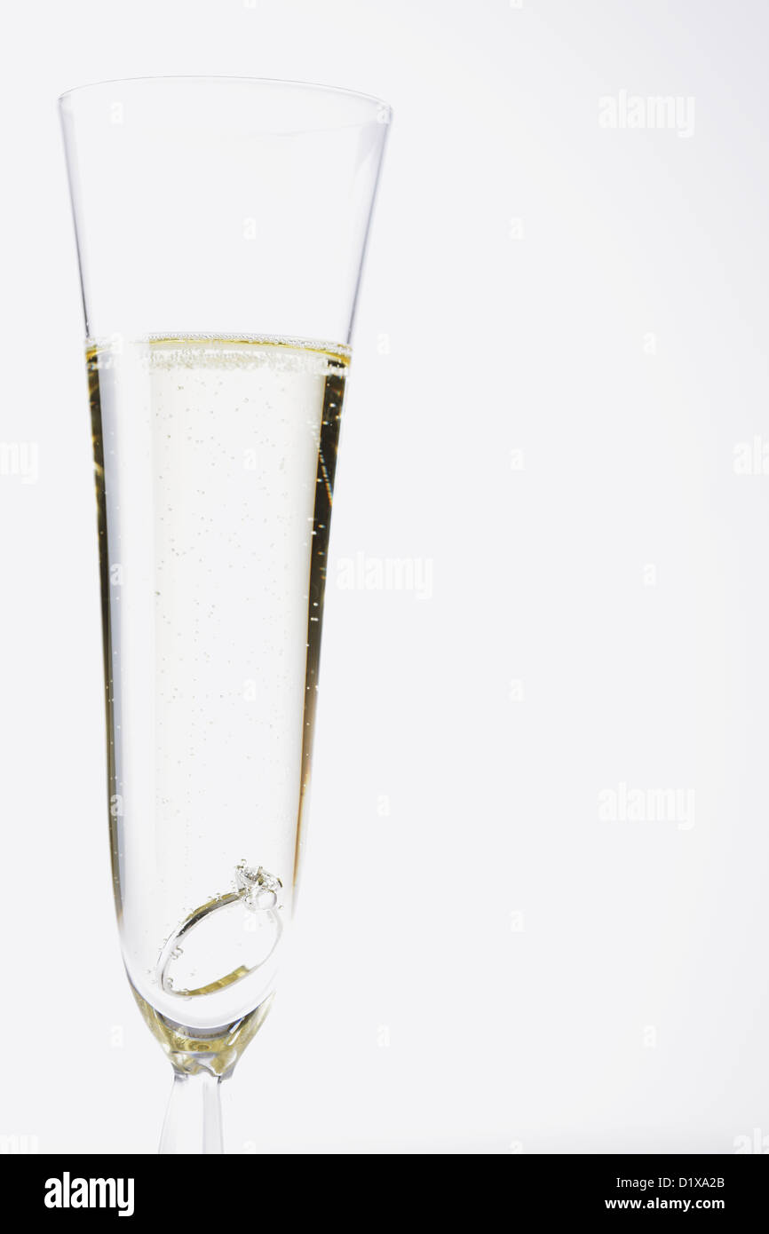 Glass of Champagne with a diamond ring in it Stock Photo