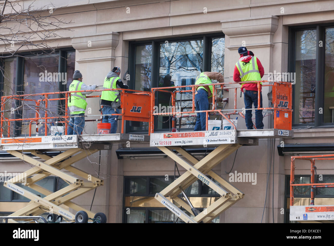 Men working top scissor lift work platform - USA Stock Photo