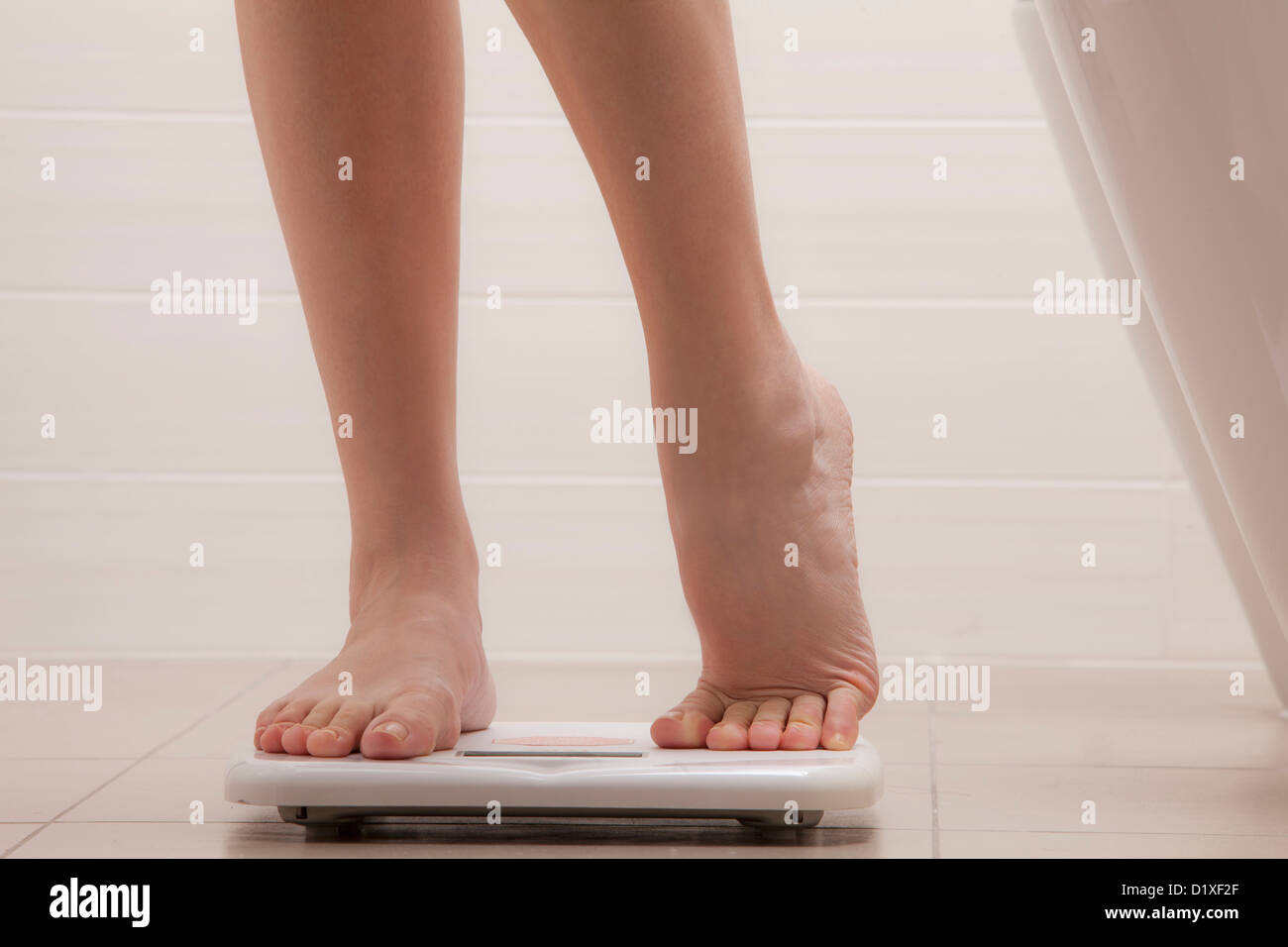 legs of woman standing on a weighing scale Stock Photo Alamy