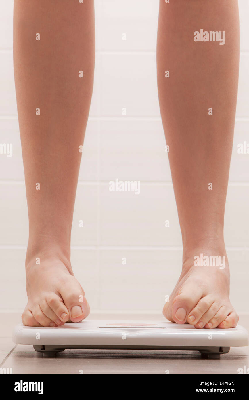 legs of woman standing on a weighing scale Stock Photo Alamy