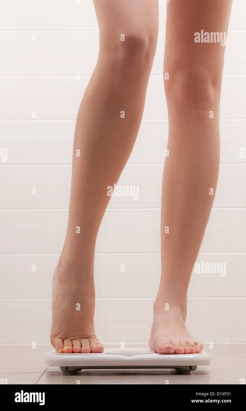 legs of woman standing on a weighing scale Stock Photo Alamy