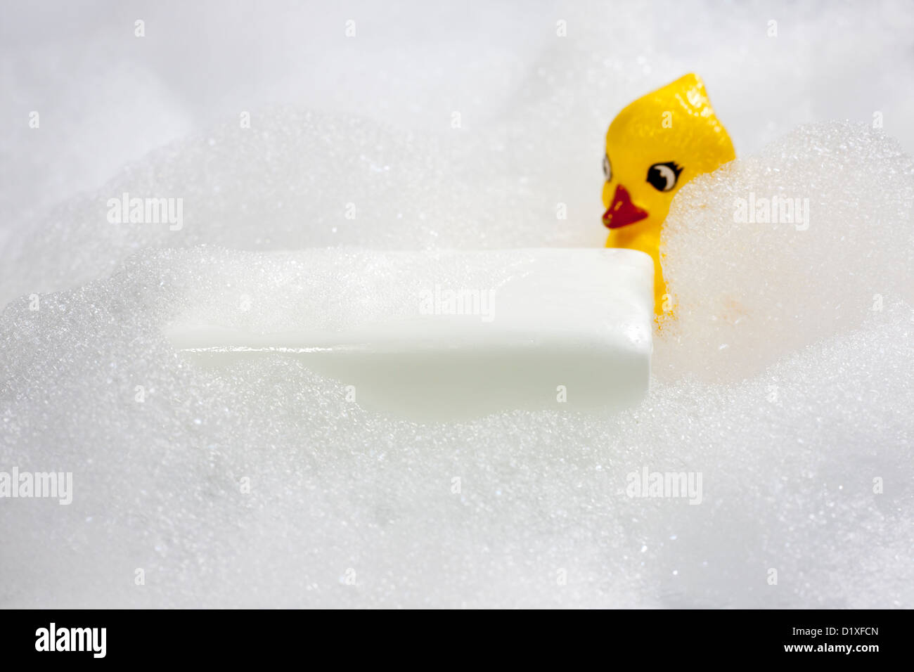 Foam and soap in bath with duck  on white Stock Photo