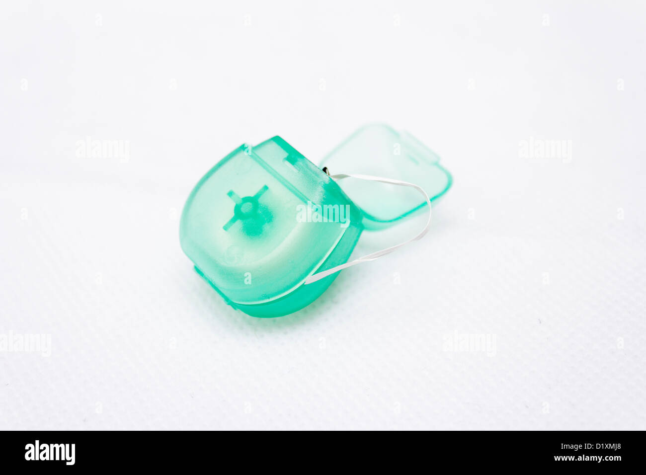 Small reel of dental floss with white background cut out Stock Photo