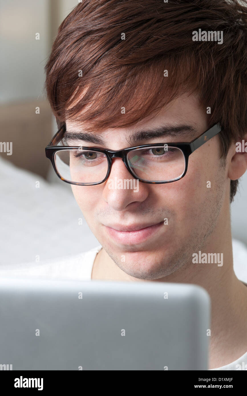 Young man wearing glasses looking at a computer screen. Stock Photo
