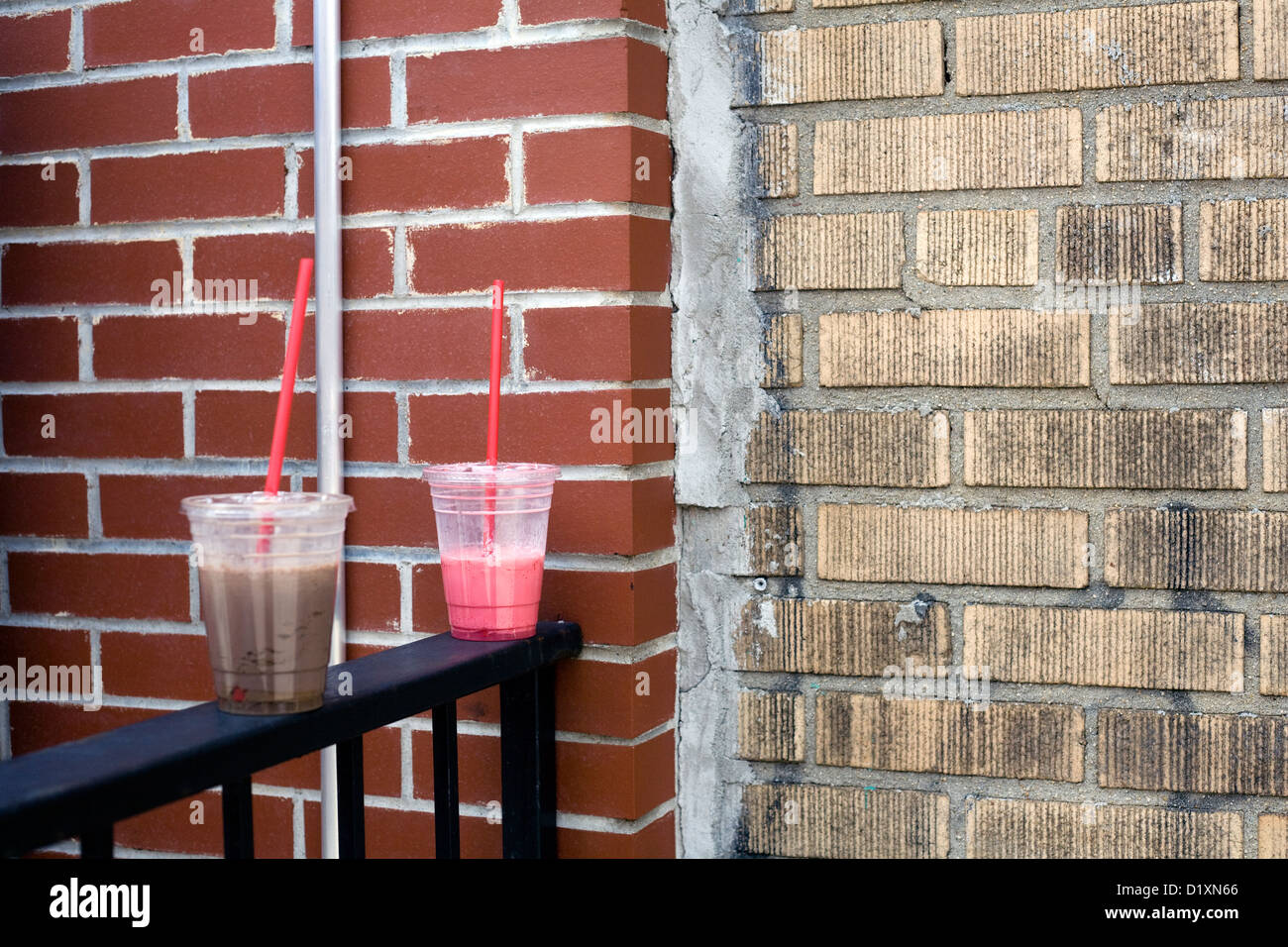 Cold drink takeout plastic cups balanced on fence Stock Photo