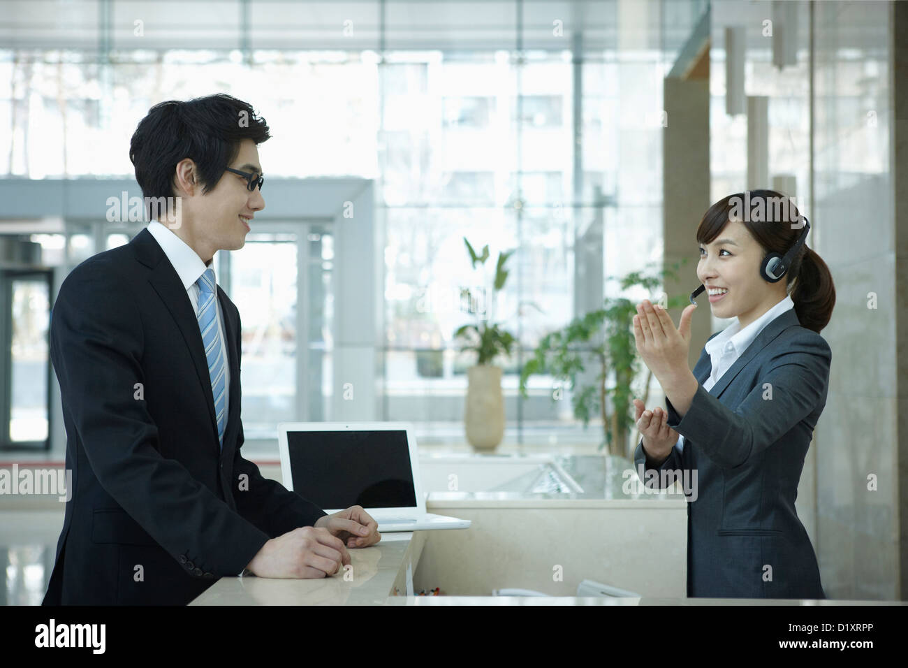 a businessman and help desk woman talking in a office building Stock Photo Alamy