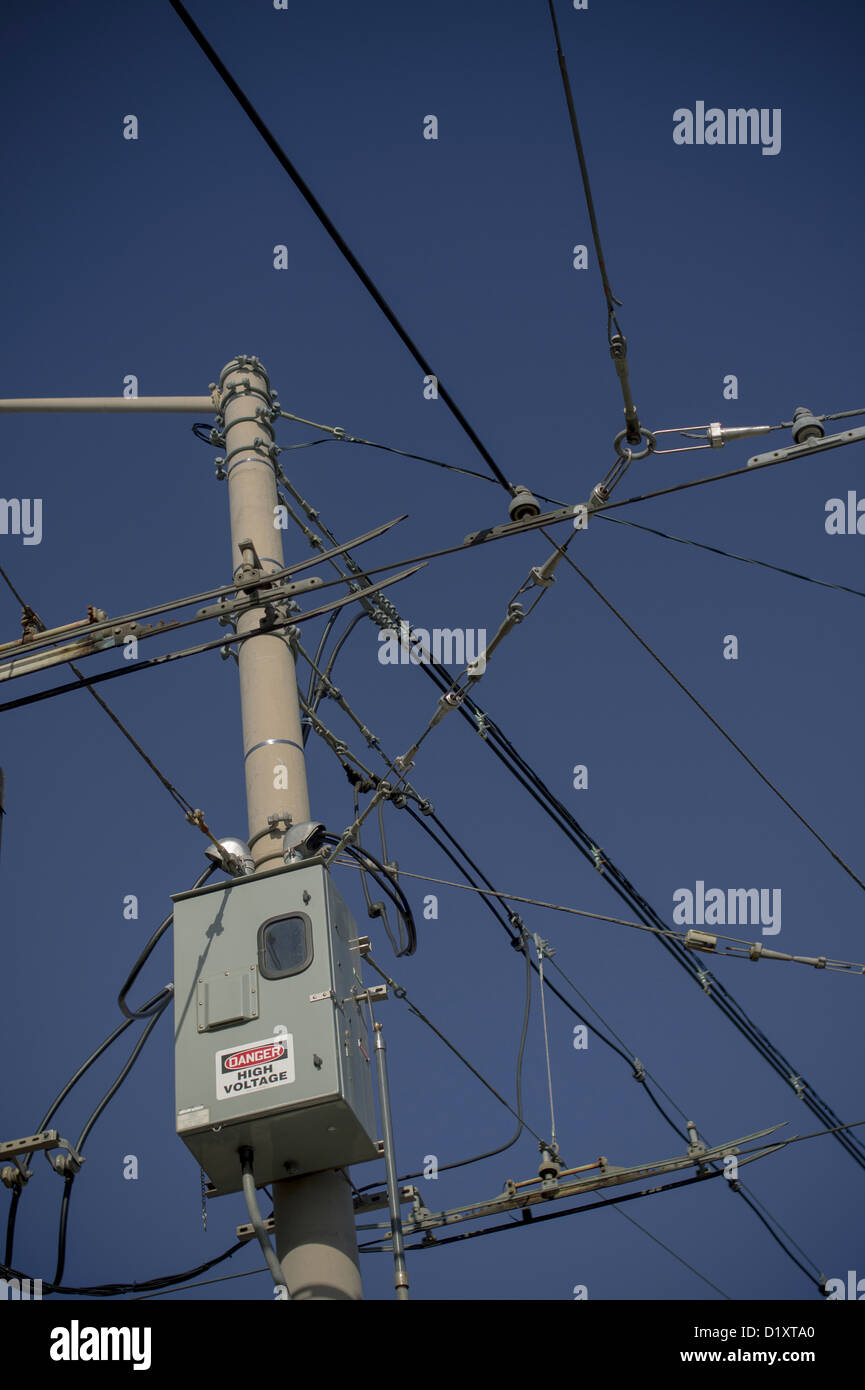 Overhead street car power cables against a blue sky Stock Photo