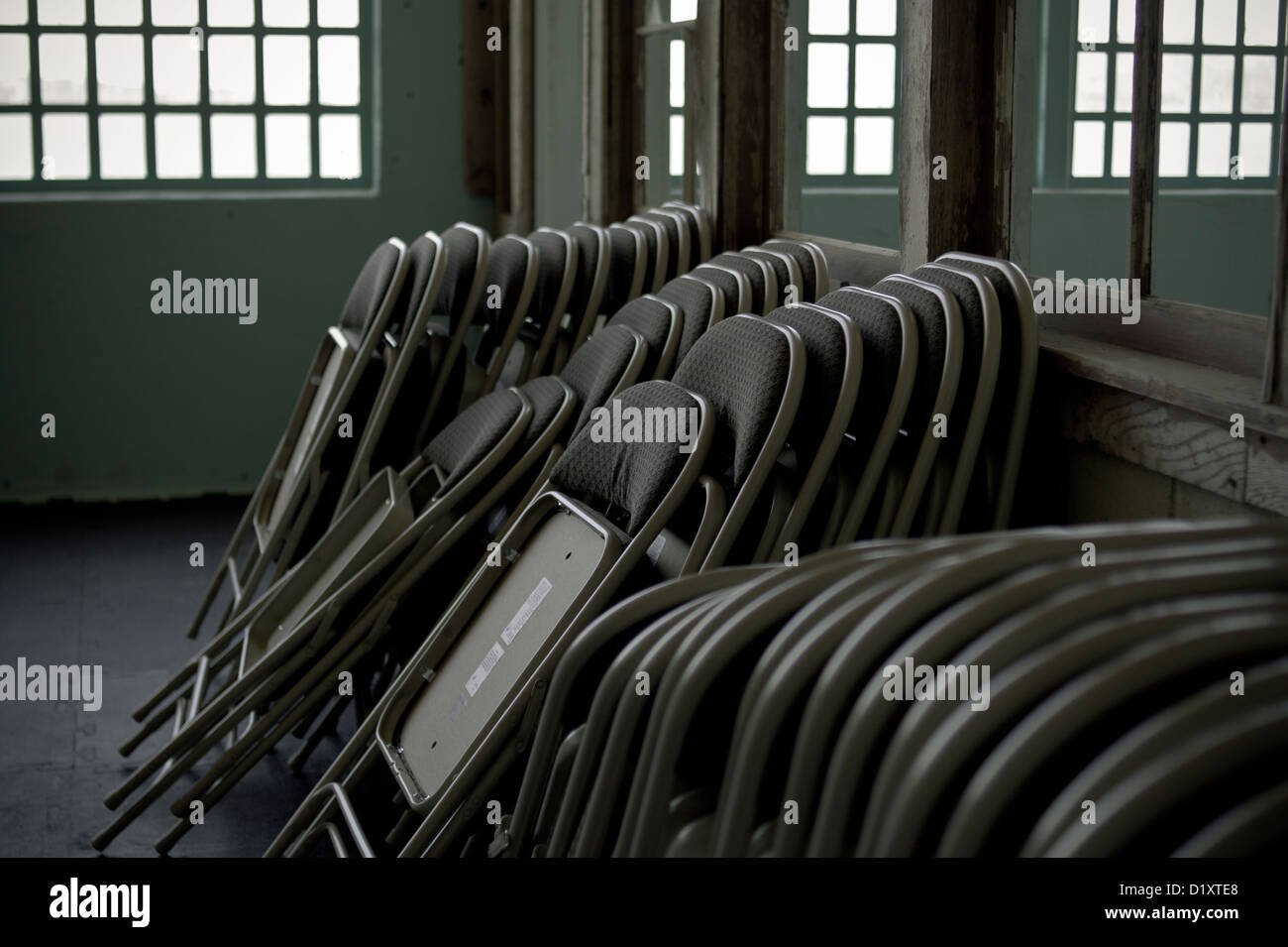 Stacked modern chairs leaning against a wall Stock Photo