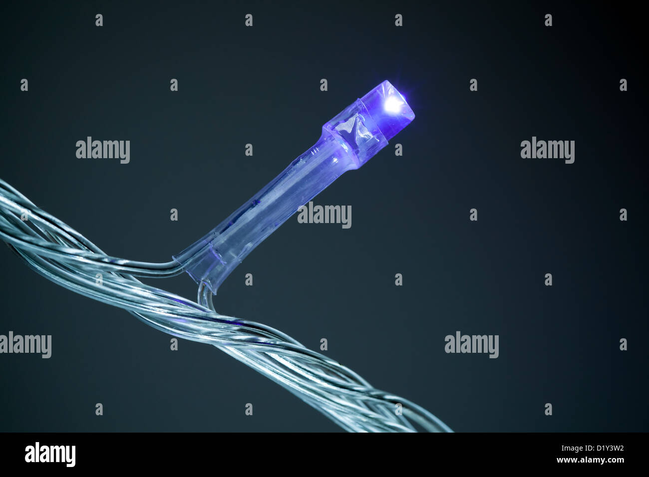 Closeup photo of blue LED (light emitting diode) light on a garland above dark background Stock Photo