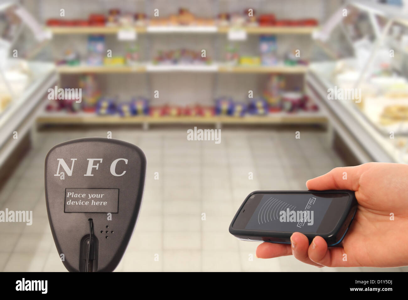 Woman with NFC smartphone paying in a supermarket Stock Photo