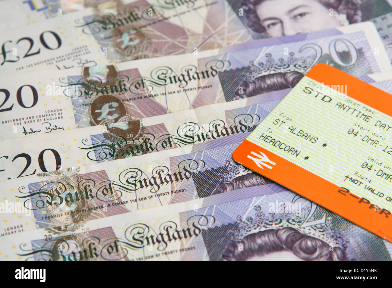 A rail ticket on top of sterling £20 notes Stock Photo