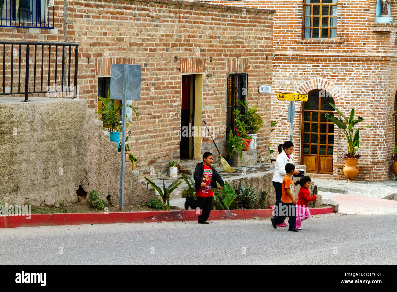Woman and children crossing a street in Todos Santos, Baja, Mexico Stock Photo