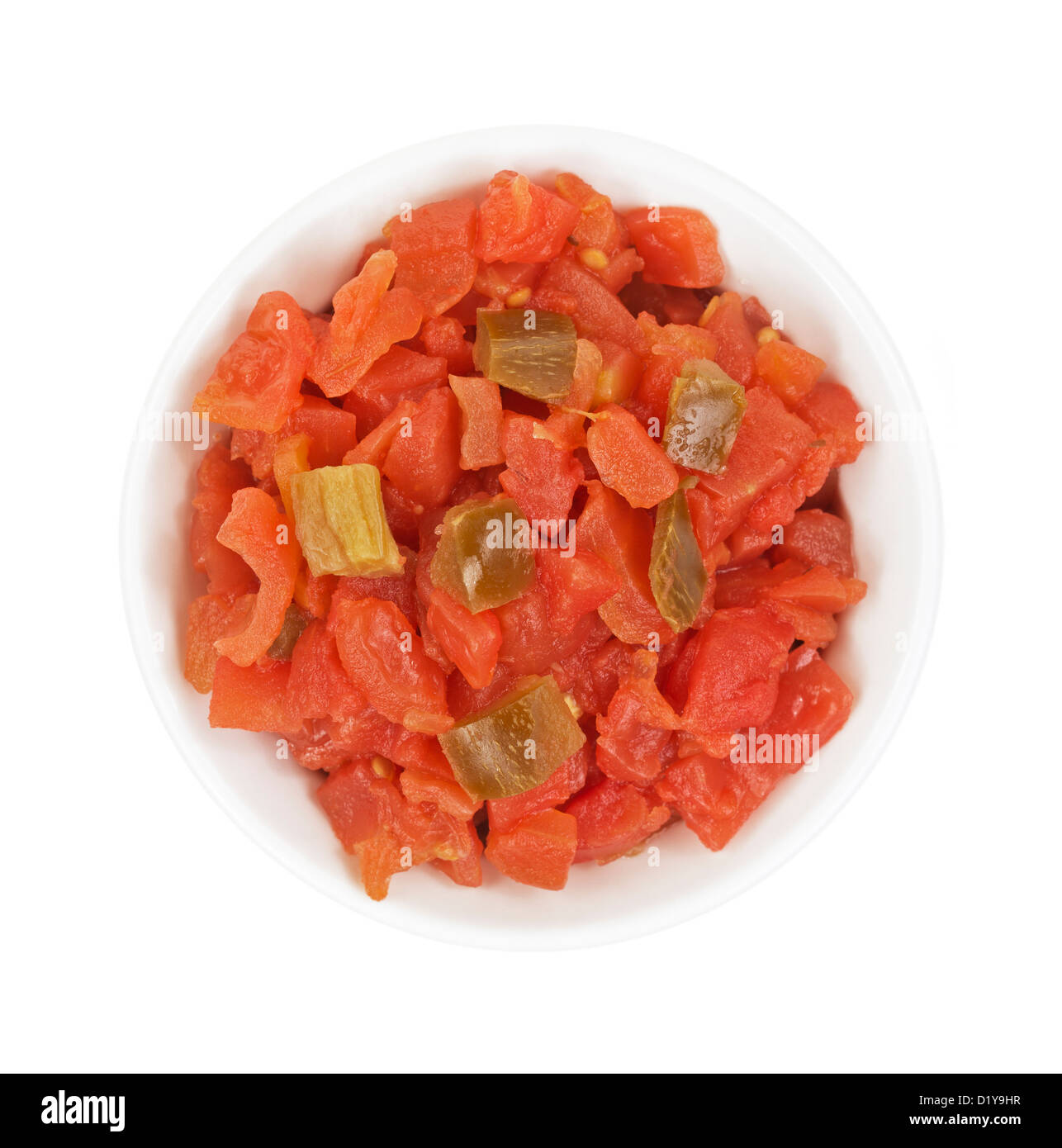Top view of a small bowl filled with diced tomatoes topped with green peppers on a white background. Stock Photo